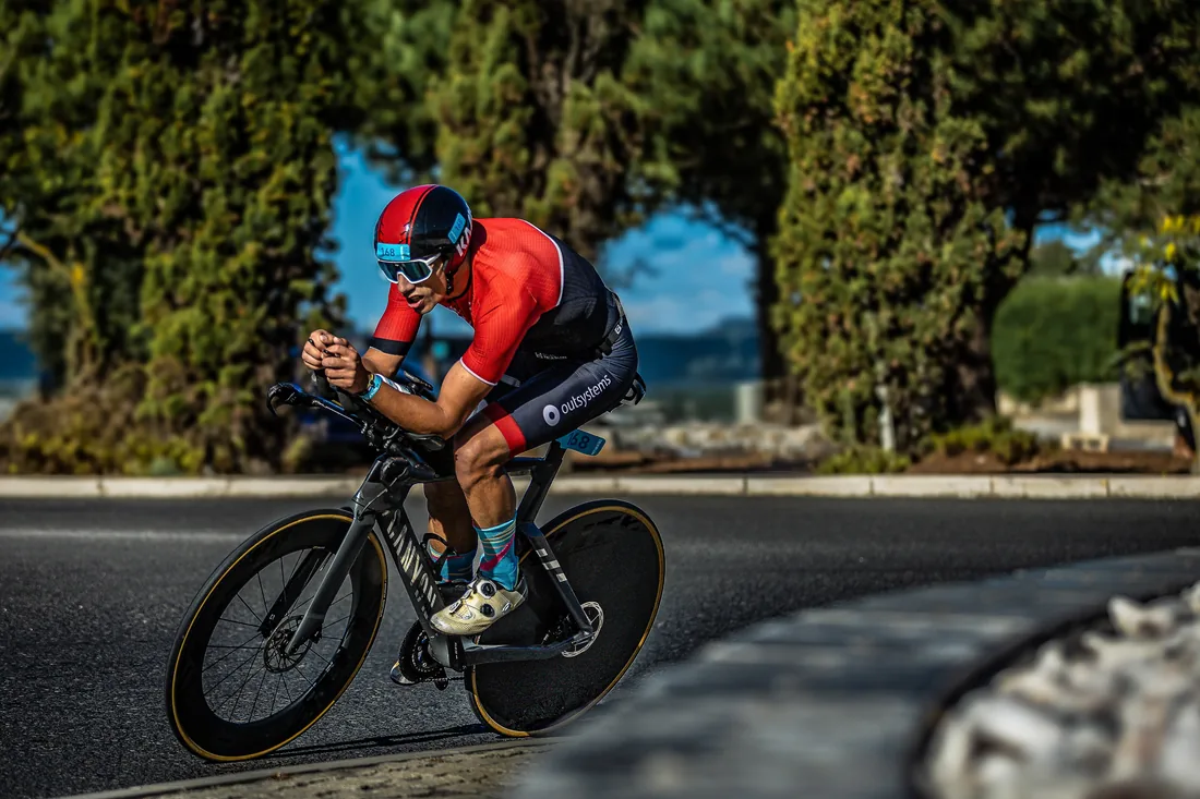 Triatleta em bicicleta de contrarrelogio numa curva de estrada